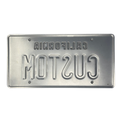 This is the backside of the embossed black and yellow California Legacy style license plate in which you can see both the California and the letters are stamped into the license plate. 